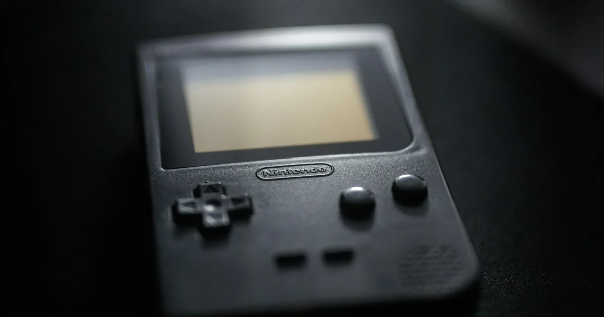 Close-up of a black Game Boy Pocket handheld console on a dark surface