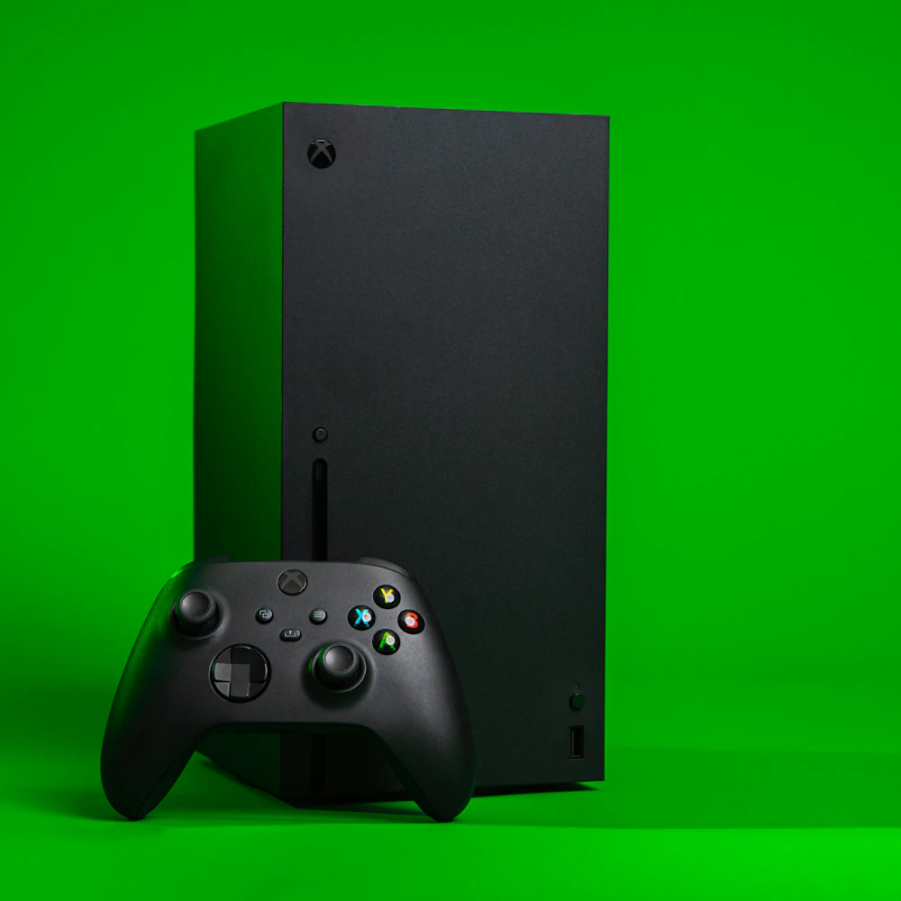 Black Xbox Series X console with wireless controller on a green background